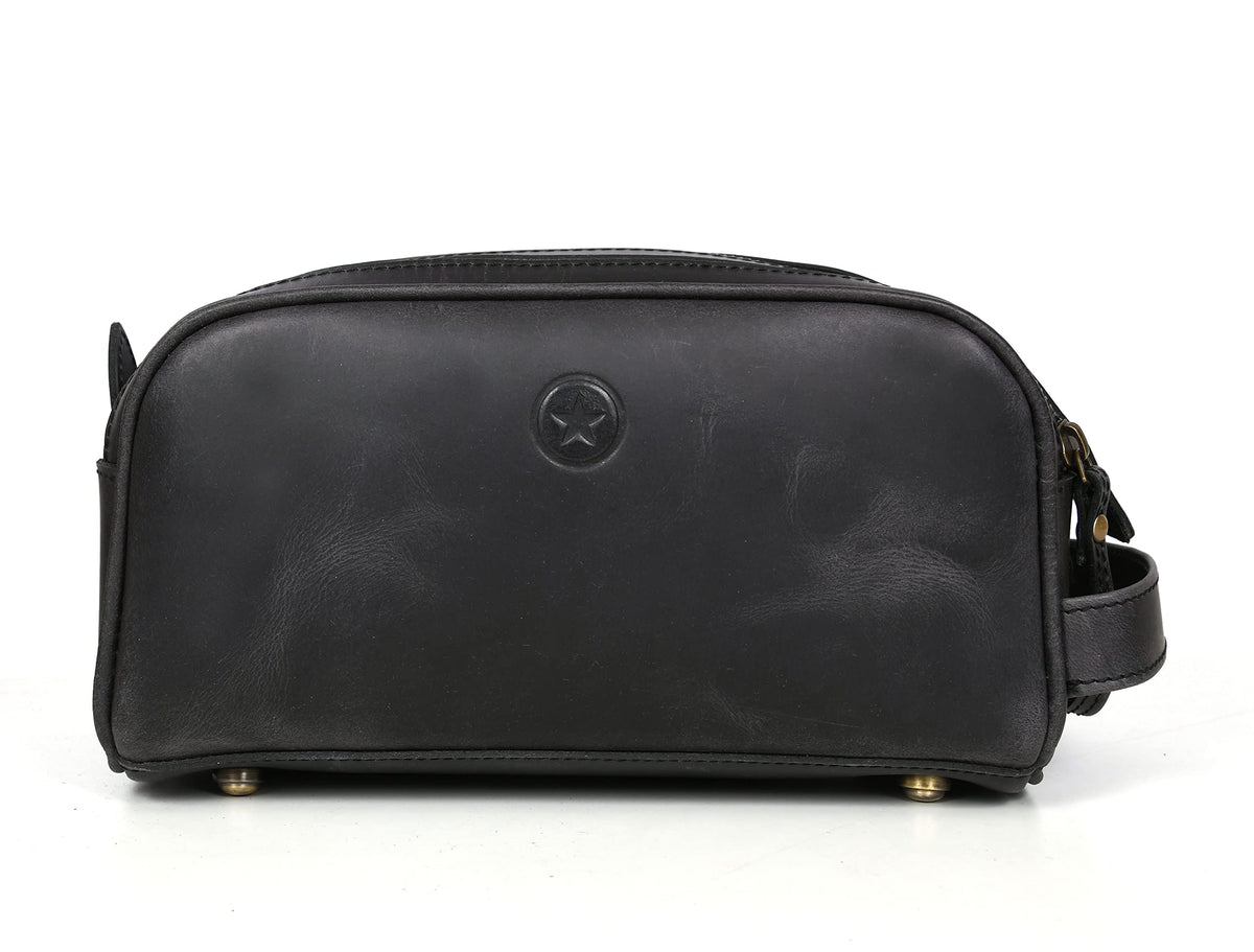 AARON LEATHER GOODS leather toiletry pouch displayed in a travel setting
