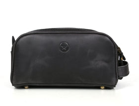 AARON LEATHER GOODS leather toiletry pouch displayed in a travel setting