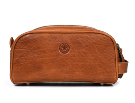 AARON Leather Toiletry Bag lifestyle shot on a travel suitcase