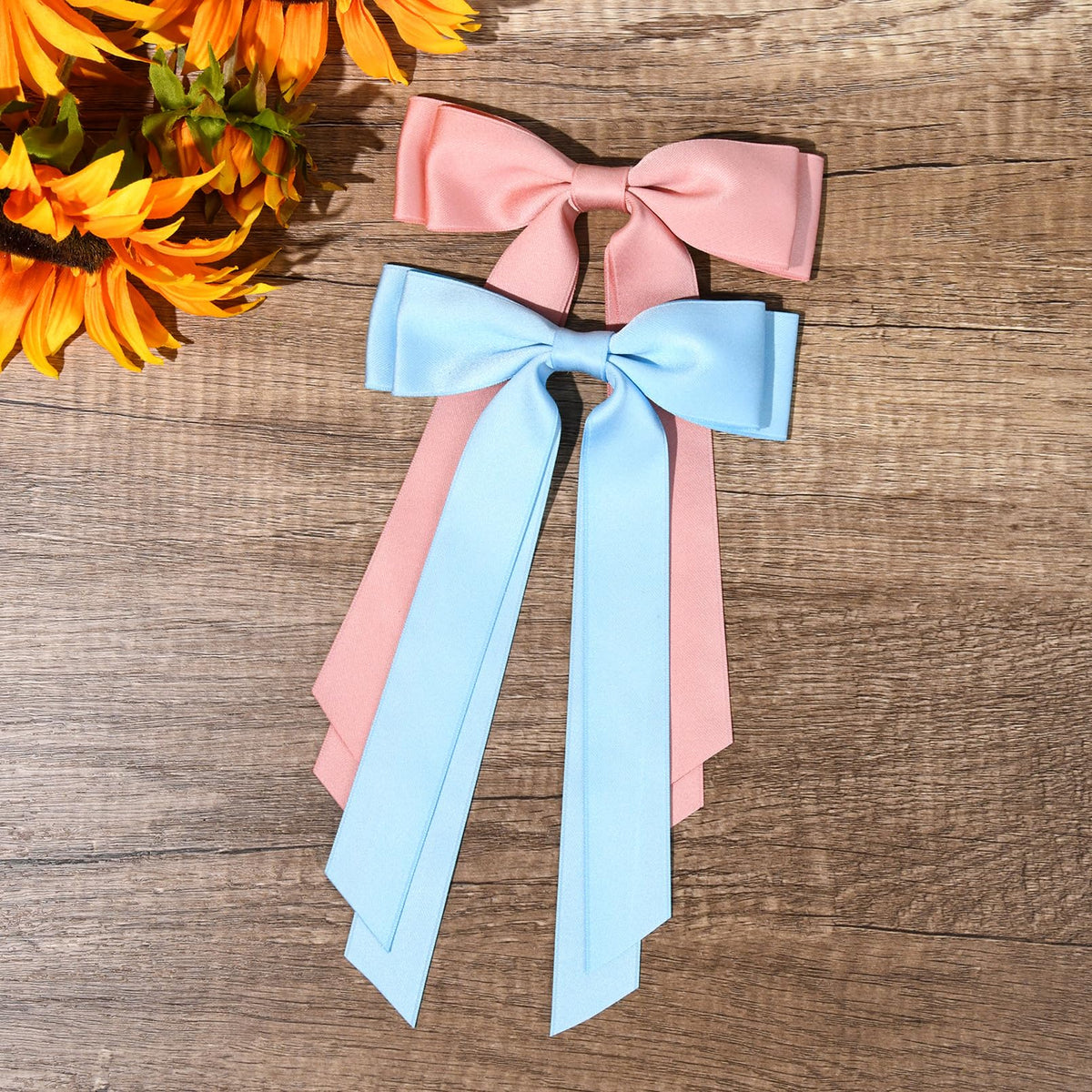 Aileam Silky Satin Hair Bows in pink and blue on a table