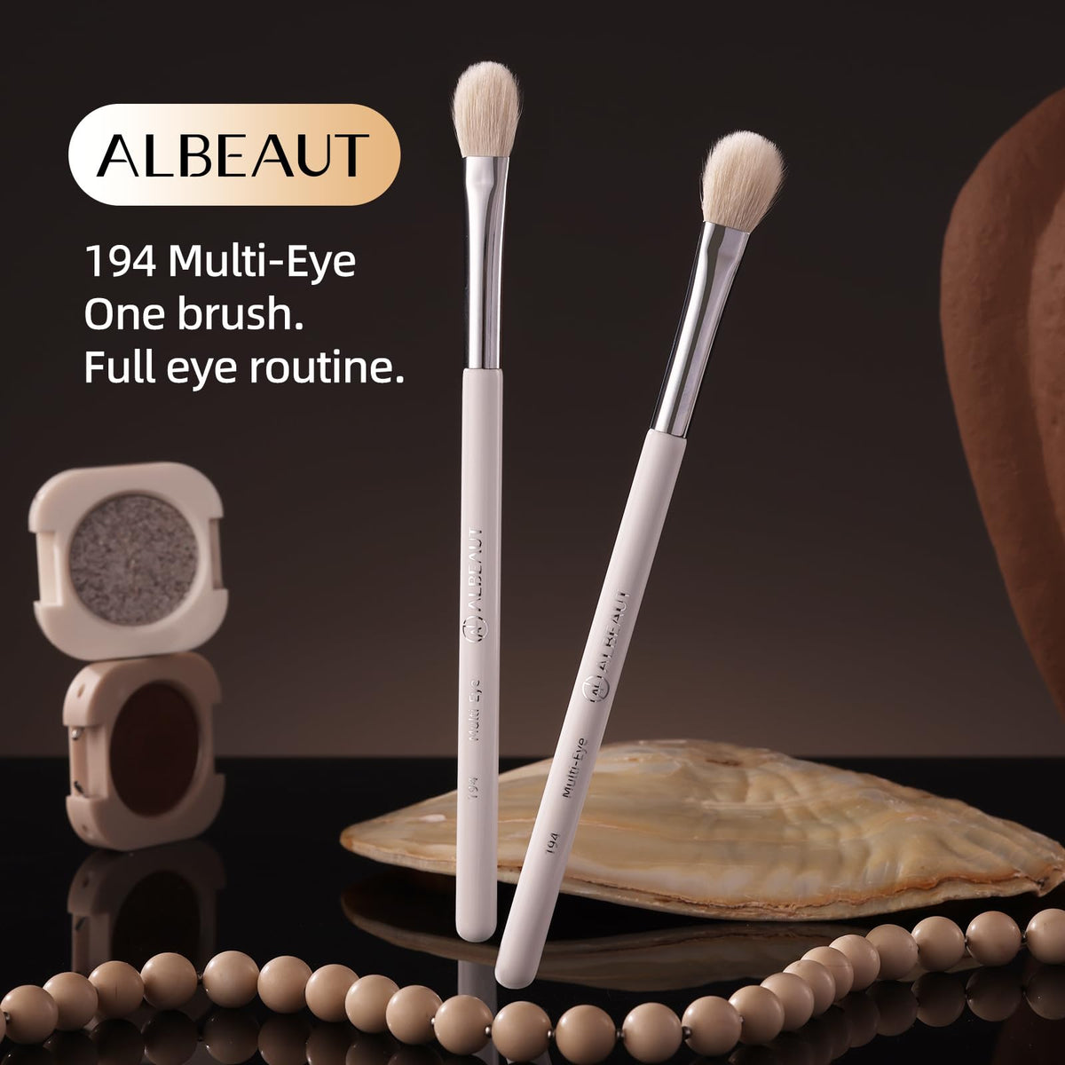 ALBEAUT Eyeshadow Brush with a background of various eyeshadow palettes