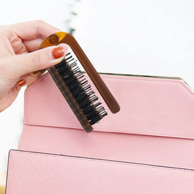 Ancable Travel Folding Hair Brush on a bathroom counter