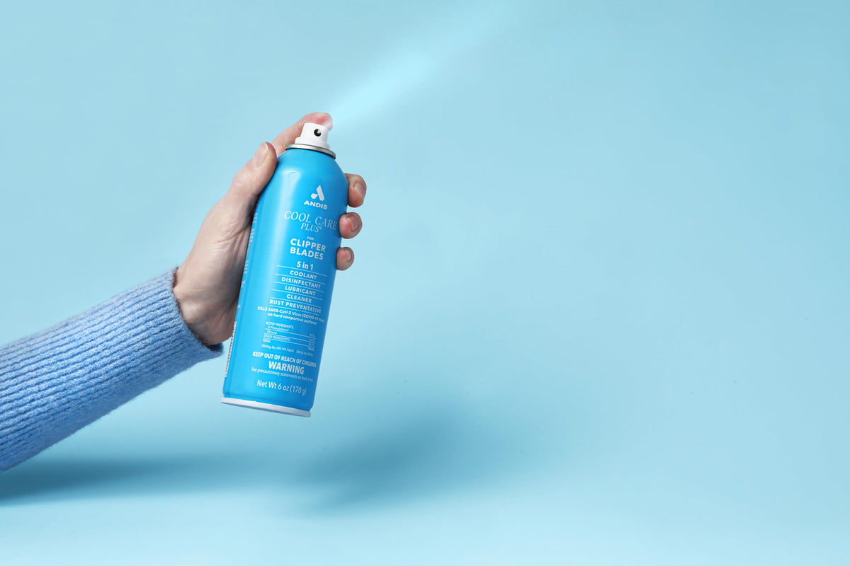 Andis Cool Care Plus 5-in-1 Clipper Blade Spray in use on clippers