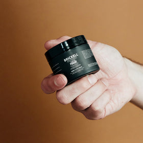 Brickell Men's Hair Styling Clay Pomade on a grooming table