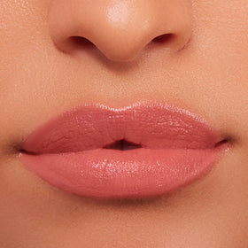 Buxom Power-Full Plumping Lip Balm Inner Glow with natural lighting