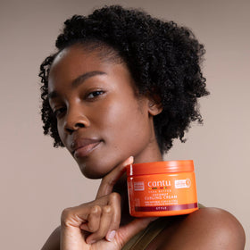 Cantu Coconut Curling Cream 12 oz displayed on a bathroom shelf