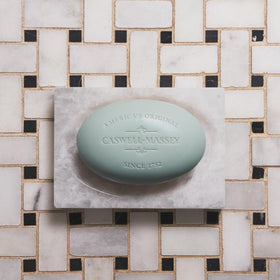 Caswell-Massey soap bar with floral elements around