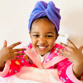 Child applying Piggy Paint Cutie Fruity Nail Polish