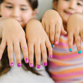 Child smiling while showing off painted nails with Piggy Paint