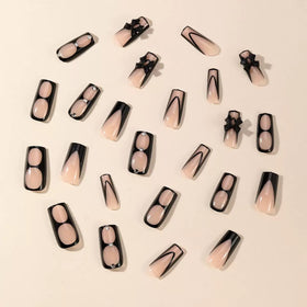 Close-up of CTTHNBD black French tip press on nails showing bow rhinestone detail
