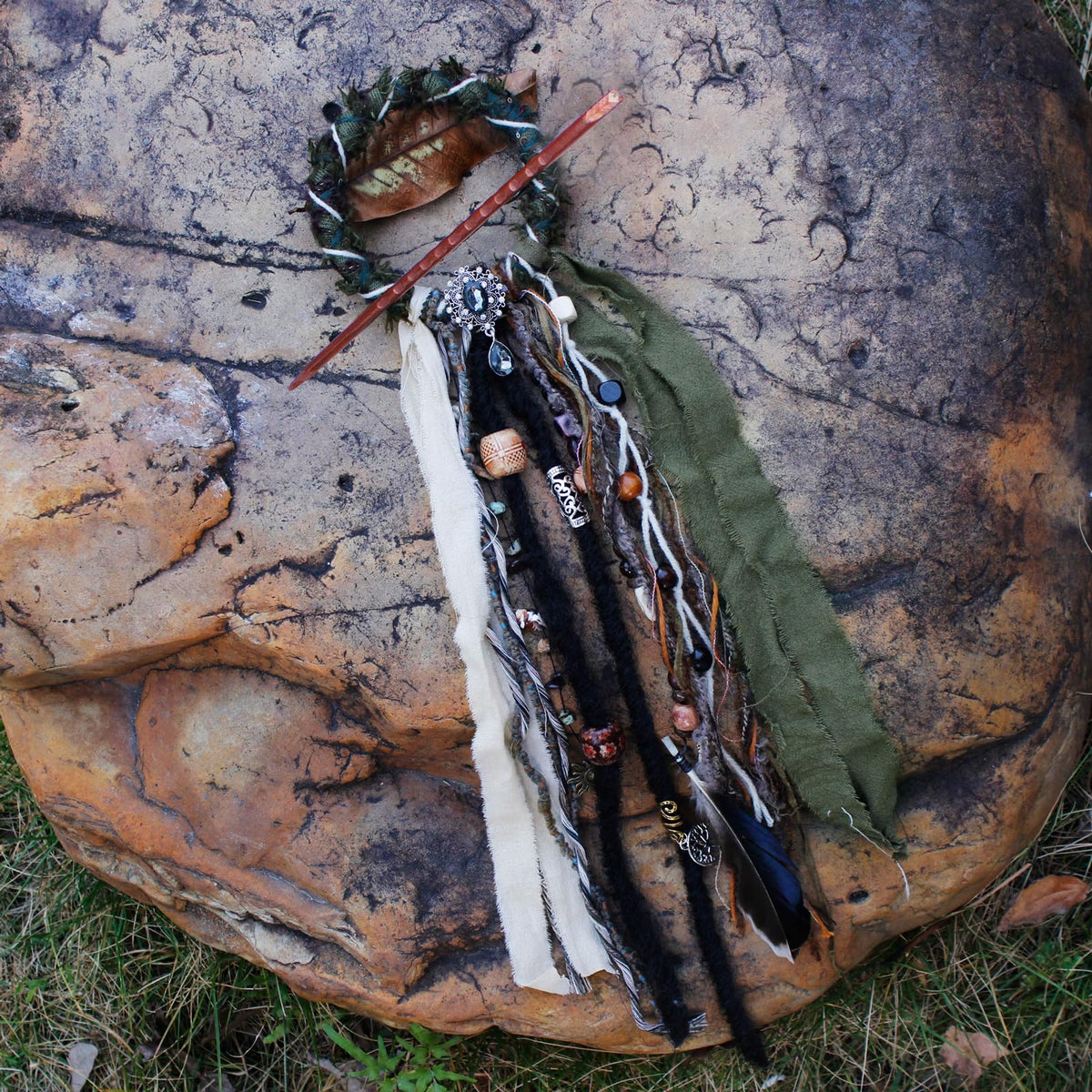 Close-up of dreadlock hair tie with shells and feathers
