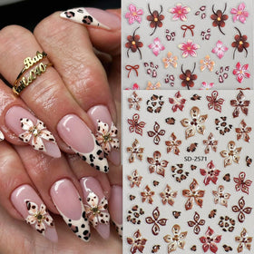 Close-up of hibiscus floral nail stickers in pink and brown