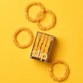 Close-up of SLIP Silk Hair Ties golden scrunchies showing texture