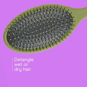 Conair detangling brush on a bathroom counter with hair products