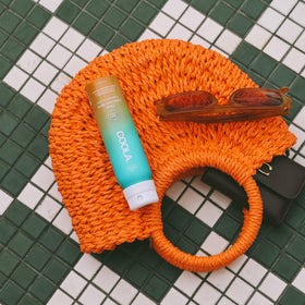 COOLA Organic Sunscreen SPF 30 Spray in lifestyle setting at the beach
