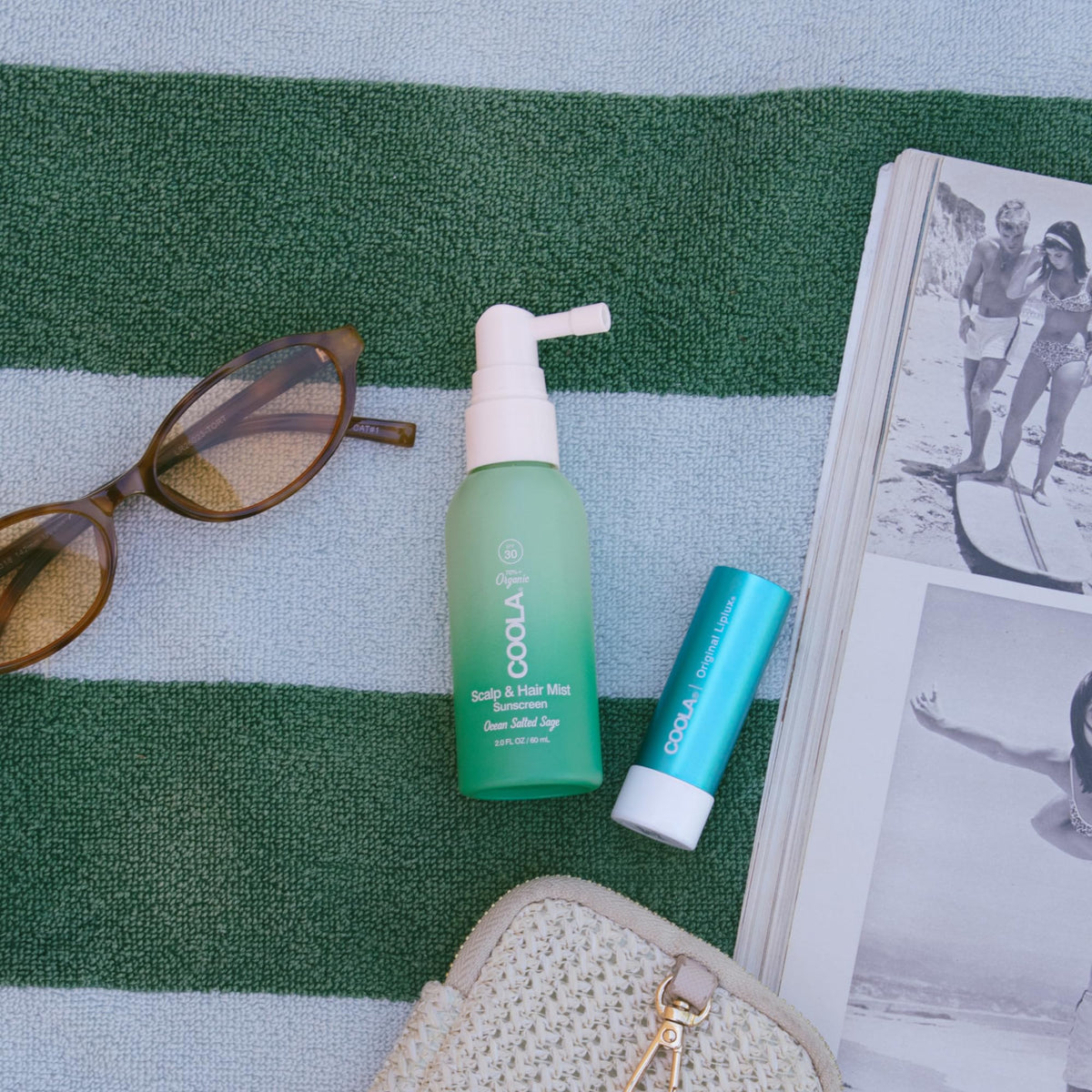 COOLA Scalp Spray in hand with ocean background