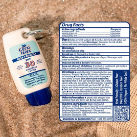 Coral Isles SPF 30 Lotion on a towel with beach accessories
