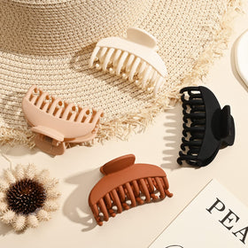 DEEKA Hair Claw Clip in matte brown on a flat surface
