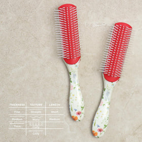 Denman D3 Curly Hair Brush displayed with hair care products