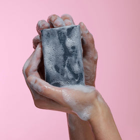 Dr. Natural Black Bar Soap displayed with natural ingredients