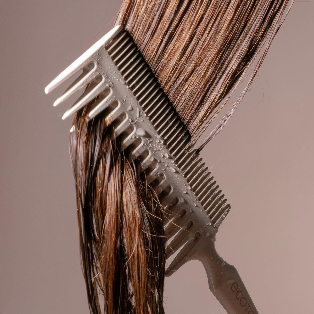 EcoTools Double-Sided Hair Comb on a wooden surface