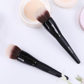 ENERGY Stippling Brush on a vanity with makeup products