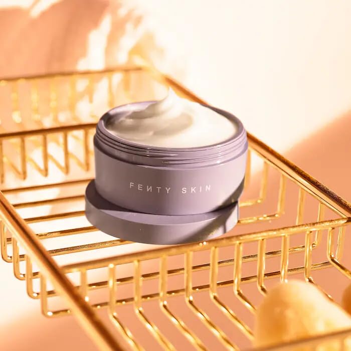 Fenty Skin Butta Drop cream lifestyle scene with flowers