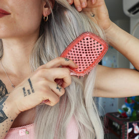 FHI Heat UNbrush Detangling Brush Ruby Peach displayed with hair care products
