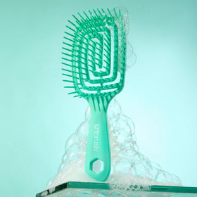 FHI Heat UNbrush Flex Detangling Brush on a vanity