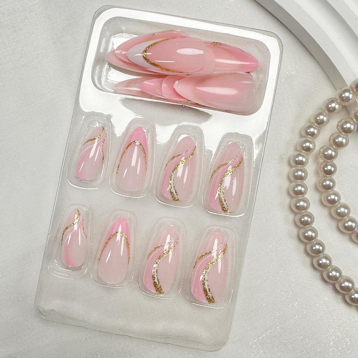 FJSMTOPl pink French tip press on nails displayed on a table