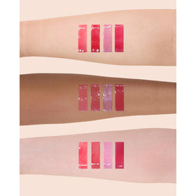 Flower Knows Hot Pink Shimmer Lip Gloss displayed with makeup accessories