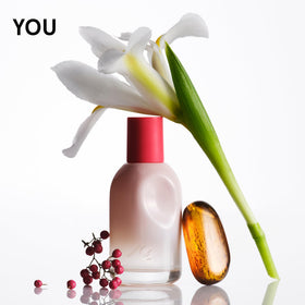 Glossier Doux fragrance bottle highlighting earthy woody notes
