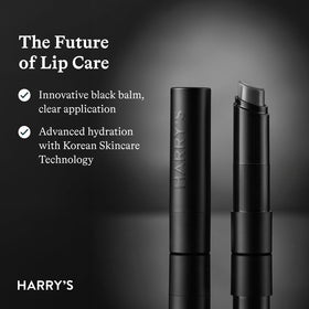 Harry's Black Lip Balm tube on a wooden surface