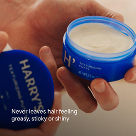 Harry's Texturizing Hair Putty on a bathroom shelf