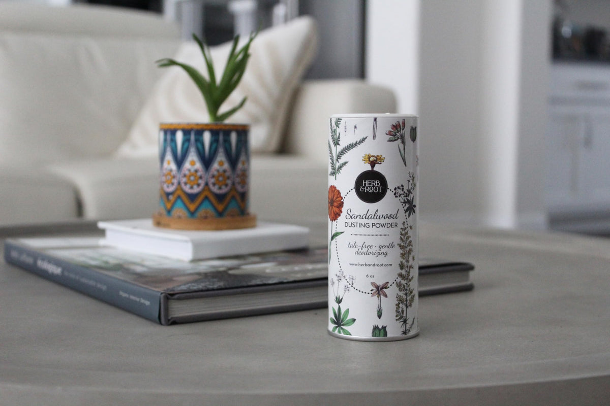 Herb & Root Sandalwood Dusting Powder on a vanity table