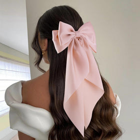 hisial large bow hair clip in peach colour on a model