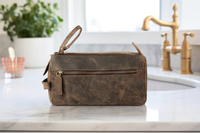 KomalC Buffalo Leather Toiletry Bag lifestyle scene on a travel suitcase