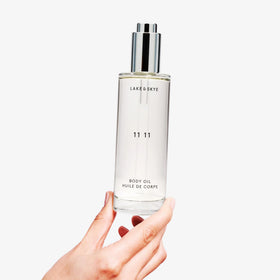 Lake & Skye 11 11 Body Oil with a towel and candle
