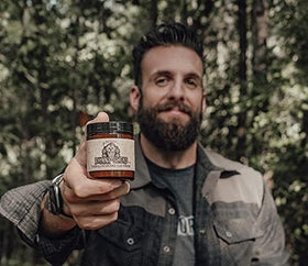 Lifestyle scene of man using Johnny Slicks Pomade outdoors