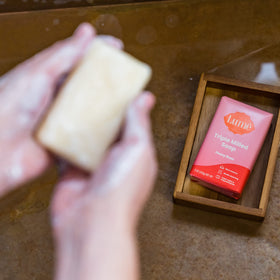 Lume Peony Rose soap bar with lather on hands