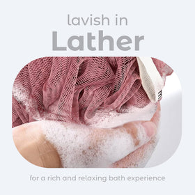 MainBasics loofah sponges in coral reef shades on a bathroom shelf