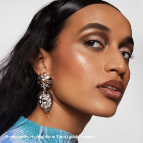 Milk Makeup Highlighter Stick displayed with other beauty products