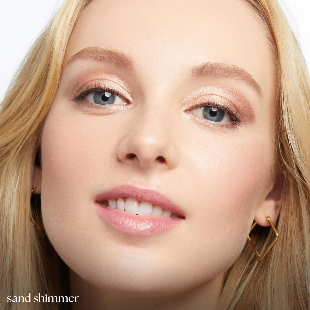 Model applying Julep Eyeshadow 101 Stick in Sand Shimmer