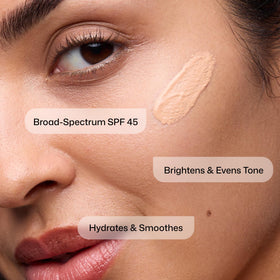 Model applying Revision Skincare Intellishade® Original Tinted Sunscreen SPF 45