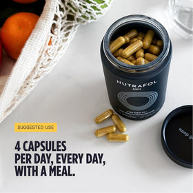 Nutrafol Men 50+ Hair Growth Supplements with a glass of water