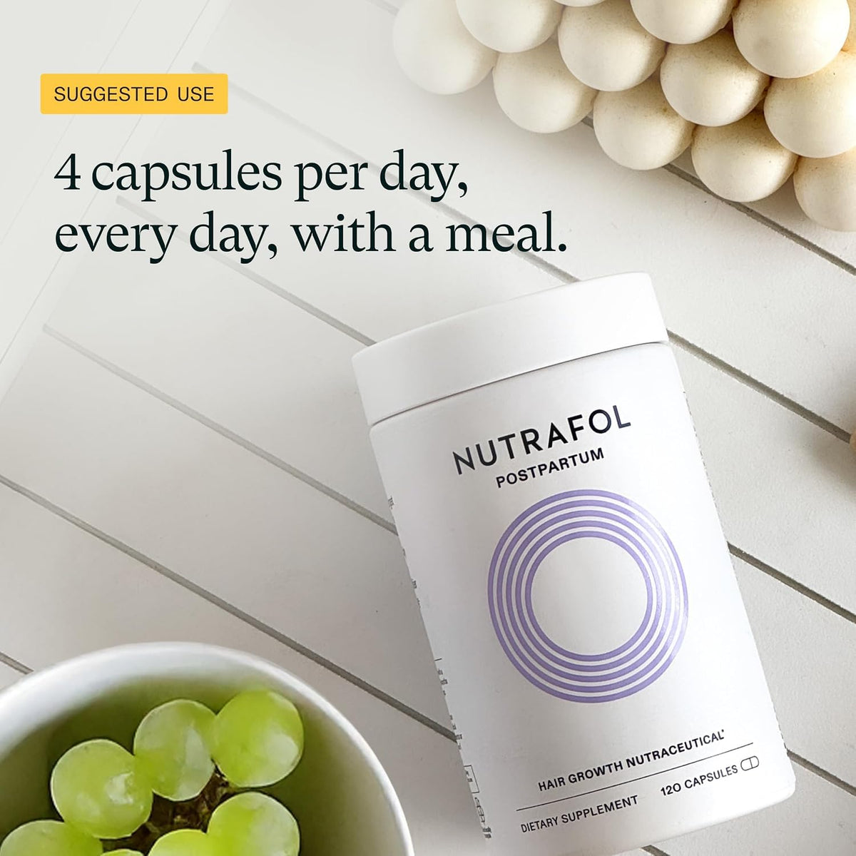 Nutrafol Postpartum Hair Growth Supplements displayed with a plant