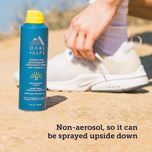 Oars + Alps SPF 30 Body Sunscreen Spray held in hand outdoors