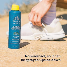Oars + Alps SPF 30 Body Sunscreen Spray held in hand outdoors