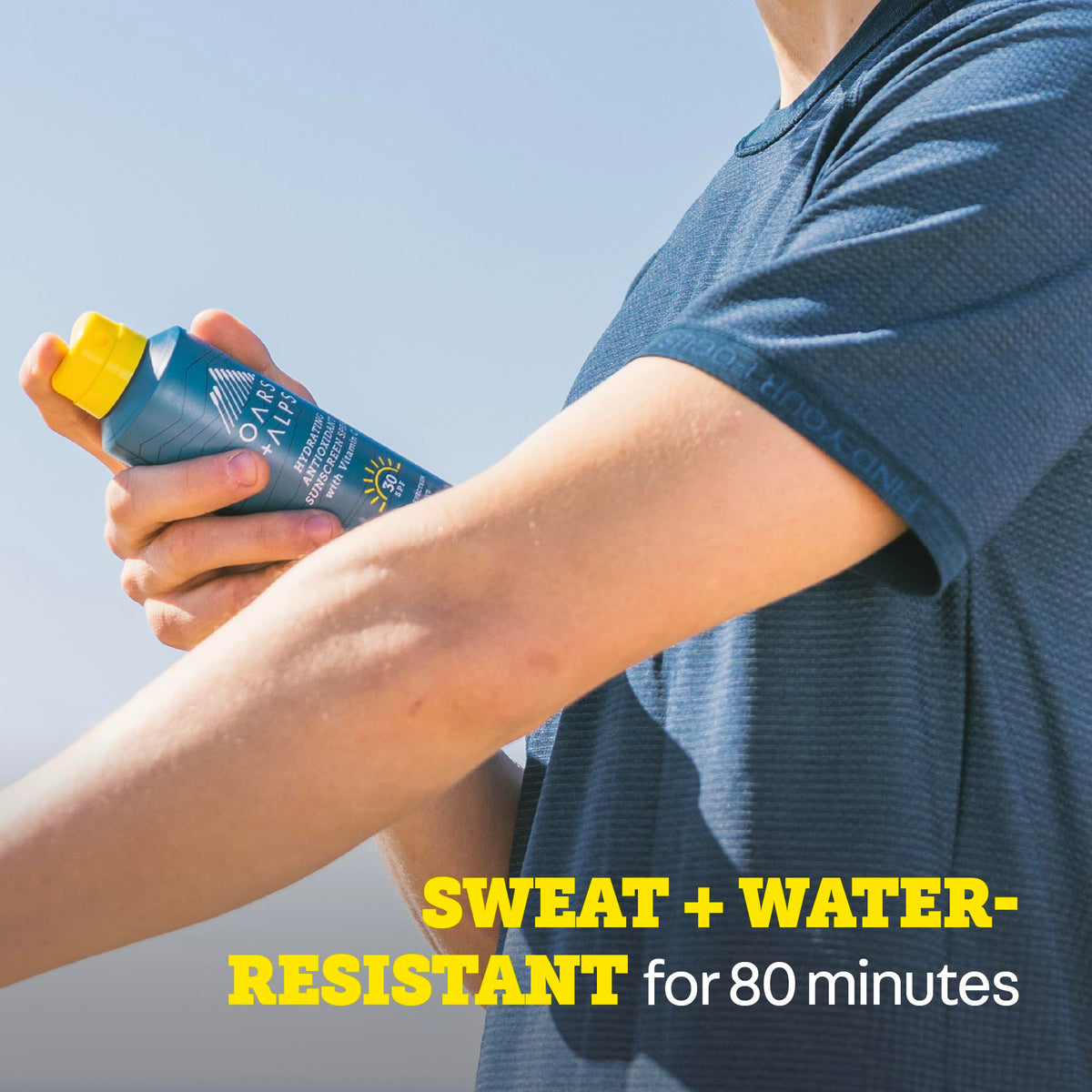 Oars + Alps SPF 30 Body Sunscreen Spray in hand outdoors