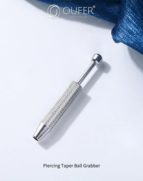 OUFER Piercing Ball Grabber Tool alongside various piercing jewellery